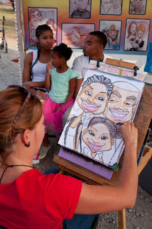 Hampton, GA, USA - September 27, 2014:  An artist draws a caricature portrait of a family at the Georgia State Fair.のeditorial素材