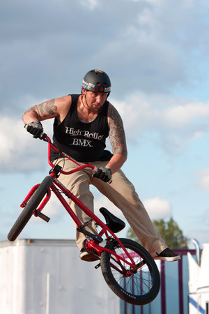 Hampton, GA, USA - September 27, 2014:  A young man with the High Roller BMX club spins his bike in midair while performing a BMX stunt at the Georgia State Fair.のeditorial素材