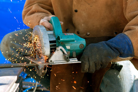 Decatur, GA, USA - October 4, 2014:  Sparks fly as an unidentified artist ues a power saw to cut...