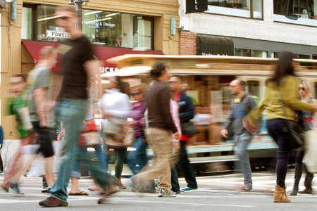 San Francisco, CA, USA - October 17, 2014:  People crossing the street and a trolley car motion blur along Powell Street in San Francisco.のeditorial素材