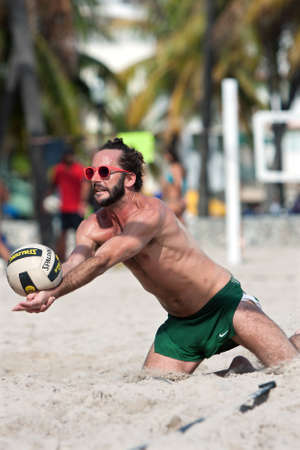 Miami, FL, USA - December 27, 2014:  A man lunges into the sand to dig the ball in a pickup game of beach volleyball on a public beach off Ocean Drive in Miami.のeditorial素材