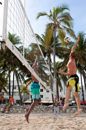 Miami, FL, USA - December 27, 2014:  A man jumps high to spike the ball in a pickup game of beach volleyball on a public beach off Ocean Drive in Miami.のeditorial素材