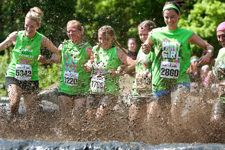 Atlanta GA USA  April 28 2012: A group of young women join arms and stomp through a mud pit together at The Dirty Girl Mud Run in Atlanta.のeditorial素材