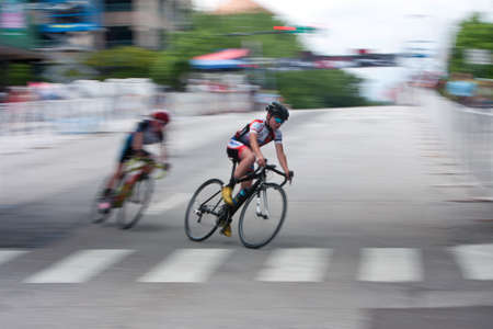 Athens, GA, USA - April 25, 2015:  Motion blur of teenage cyclist competing in an amateur race on the streets of downtown Athens, in the annual Twilight Criterium on April 25, 2015 in Athens, GA.のeditorial素材