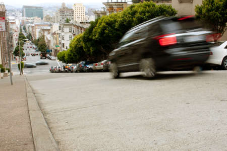 San Francisco, CA, USA - May 18, 2015:  A car motion blurs while braking down a steep hill in the Nob Hill area of San Francisco.のeditorial素材