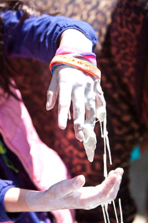 Atlanta, GA, USA - March 28, 2015:  A kid tries to catch the goo dripping from one hand made from corn starch and water, at the Atlanta Science Fair at Centennial Park in Atlanta.のeditorial素材