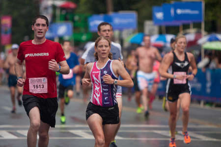 Atlanta, GA, USA - July 4, 2015:  Tired runners push for the finish line in the rain, at the 46th running of the Peachtree Road Race 10K in Atlanta.のeditorial素材