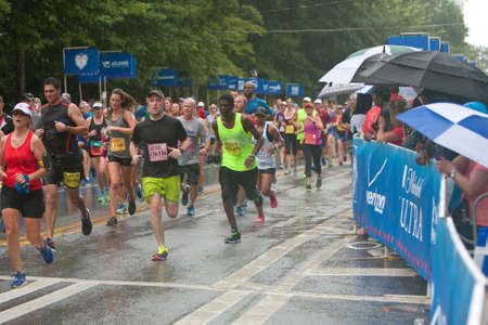 Atlanta, GA, USA - July 4, 2015:  Exhausted runners approach the finish line in the rain at the 46th running of the Peachtree Road Race 10K in Atlanta.のeditorial素材