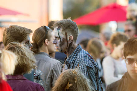 Canton, GA, USA - October 17, 2015:  A man dressed as a ragged, bloody zombie wanders among the crowd at the Cherokee Zombie Fest in Canton, GA.のeditorial素材