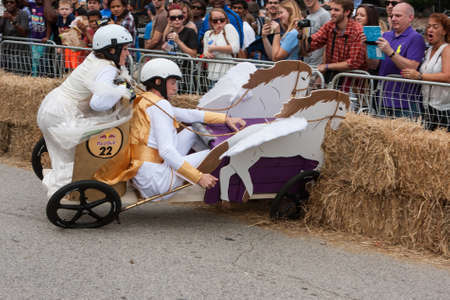 Atlanta, GA, USA - October 24, 2015:  Competitors racing a soap box derby car designed like a Roman chariot crash into hay bales at the Red Bull Soap Box Derby on North Avenue in Atlanta, GA.のeditorial素材