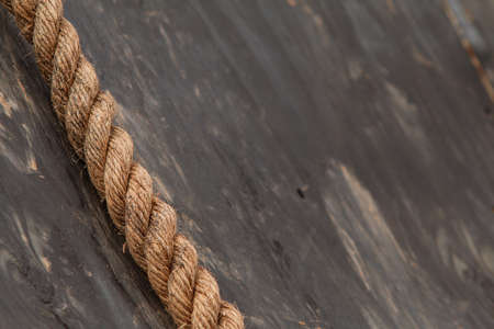 Closeup of thick rope lying against wooden wall at extreme obstacle course race.の写真素材