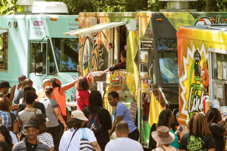 Atlanta, GA, USA - April 16, 2016:  A crowd of people buy meals from food trucks lined up in Grant Park at the Food-o-rama festival on April 16, 2016 in Atlanta, GA.