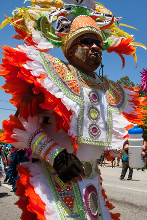 Atlanta, GA, USA - May 28, 2016:  Man wearing colorful, elaborate feathered costume blows whistle...