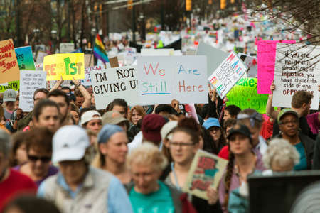 Atlanta, GA, USA - January 21, 2017:  A group of protest signs rise above the crowd as thousands of protesters walk in the Atlanta march for social justice and women, the day after President Trump's inauguration, on January 21, 2017 in Atlanta, GA.のeditorial素材