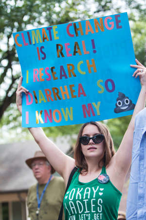 Atlanta, GA, USA - March 22, 2017:  A young woman holds up a funny sign about climate change as she takes part in the Atlanta March for Science near Candler Park on Earth Day on April 22, 2017 in Atlanta, GA.のeditorial素材