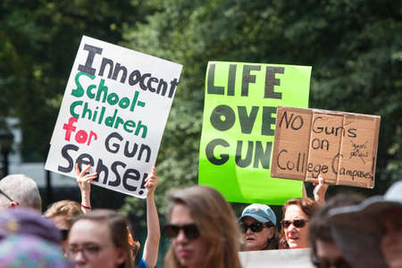 Atlanta, GA, USA - April 29, 2017:  People hold up signs at a Moms Demand Action anti-gun, anti-NRA rally in Woodruff Park, on April 29, 2017 in Atlanta, GA.のeditorial素材