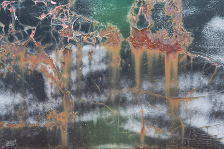 Chipped paint and cracks on a junkyard vehicle create an interesting grunge texture