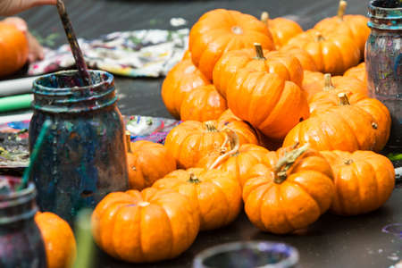Miniature pumpkins sit on arts and crafts table waiting to be painted at fall festival. の写真素材