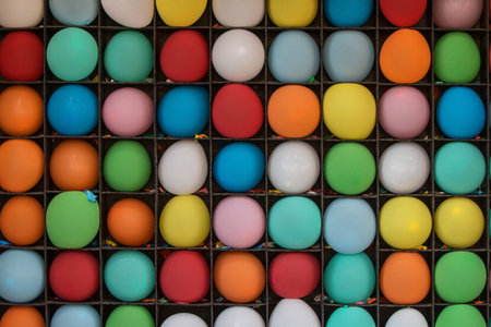 Inflated balloons waiting to be popped sit on shelves of carnival game at county fair. の写真素材