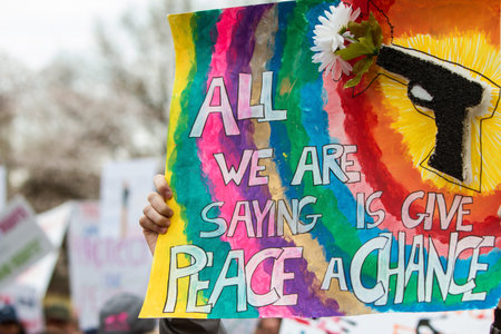 Atlanta, GA, USA - March 24, 2018:  Hands hold up a sign that says All we are saying is give peace a...