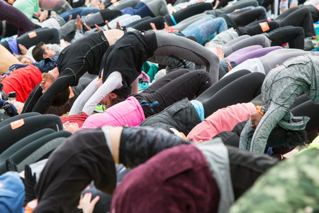 Atlanta, GA, USA - April 8, 2018:  Dozens of people do the upward bow pose as they take part in a...