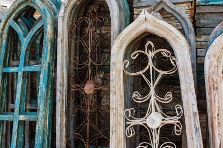 Braselton, GA, USA - April 28, 2018:  Vintage arched stained glass window frames that have been turned into art objects, are stacked for sale at an antique festival on April 28, 2018 in Braselton, GA.のeditorial素材