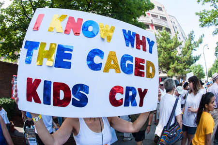 Atlanta, GA, USA - June 30, 2018:  A woman holds a sign saying "I know why the caged kids cry" at an immigration law protest in Atlanta, GA.のeditorial素材