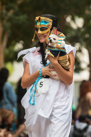 Atlanta, GA, USA - August 18, 2018:  A young woman dressed as an ancient Egyptian carries her small dog dressed as a pharaoh at Doggy Con, an event where dogs and their owners wear costumes and are judged for prizes, on August 18, 2018 in Atlanta, GA.のeditorial素材