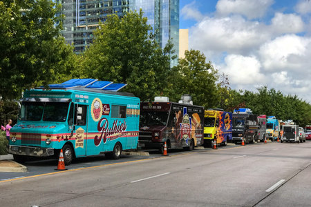 Dallas, TX, USA - October 6, 2018:  Several colorful food trucks are parked all in a row on a street...