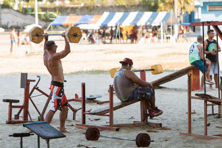 Sao Vicente, Brazil - July 8, 2018:  Men work out with crude weightlifting equipment in an outdoor gym on a public beach on July 8, 2018 in Sao Vicente, Brazil.のeditorial素材
