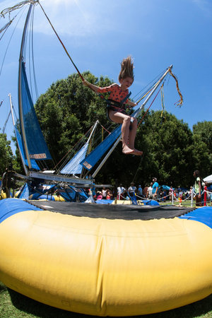 Atlanta, GA, USA - July 28, 2018:  A girl gets airborne bouncing on a bungee trampoline at the...