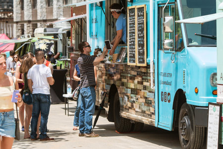 Atlanta, GA, USA - May 19, 2018:  A young man signs an electronic device with his finger as he buys food from a food truck at the Old Fourth Ward Food Truck Festival on May 19, 2018 in Atlanta, GA.