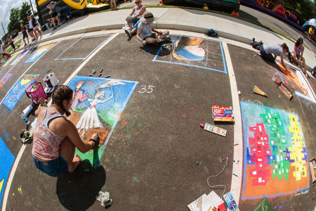 Sandy Springs, GA, USA - September 22, 2018:  Teenage girls draw chalk art on pavement in a chalk...