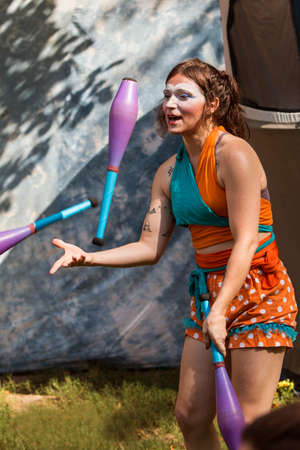 Sandy Springs, GA, USA - September 22, 2018:  A female juggler tosses juggling pins in the air as she entertains patrons at the Sandy Spring Festival on September 22, 2018 in Sandy Springs, GA.のeditorial素材