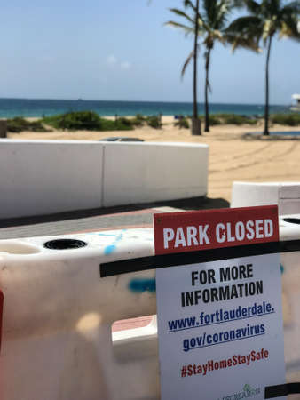 Fort Lauderdale, Florida / USA - May 21, 2020:  A sign reading "Park Closed" is attached to a barricade blocking access to a public beach, as beaches remain closed for the Covid-19 pandemic crisis, on May 21, 2020 in Fort Lauderdale, Florida.のeditorial素材