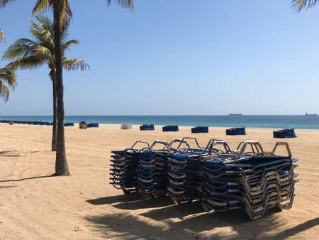 Fort Lauderdale, Florida / USA - May 21, 2020:  Beach chairs are stacked and locked as beaches remain closed for the Covid-19 pandemic public health crisis, on May 21, 2020 in Fort Lauderdale, Florida.のeditorial素材