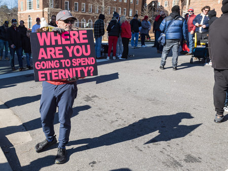 Athens, GA / USA - January 14, 2023:  A street evangelist holds a sign asking Where are you going to...
