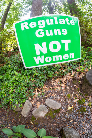 A sign in an Atlanta yard says "Regulate Guns, not women."の写真素材