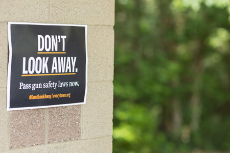 Cumming, GA / USA - June 4, 2023:  A sign reading "Don't look away, pass gun safety laws now" marks the site for people to gather for a local gun violence awareness meeting on June 4, 2023 in Cumming, GA.のeditorial素材