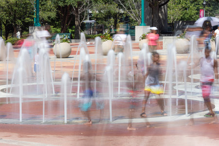 Motion blur shows unidentfiable kids playing in Centennial Olympic Park fountain on a hot summer day on August 26, 2023 in Atlanta, GA.の写真素材
