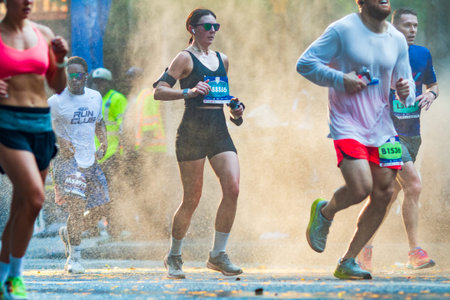 Atlanta, GA / USA - July 4, 2025:  A young female runner jogs through a cooling mist as she participates in the annual Peachtree Road Race 10K on July 4, 2025 in Atlanta, GA.のeditorial素材