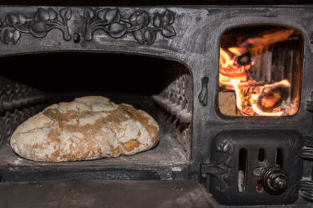 Baking bread in an old cast iron stoveの写真素材