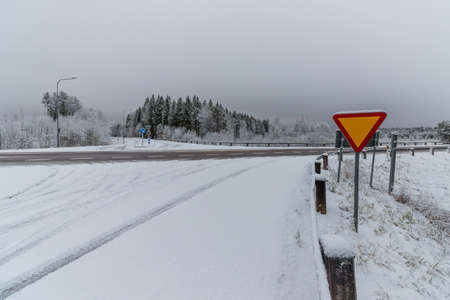 a wintery cross road with a signの写真素材