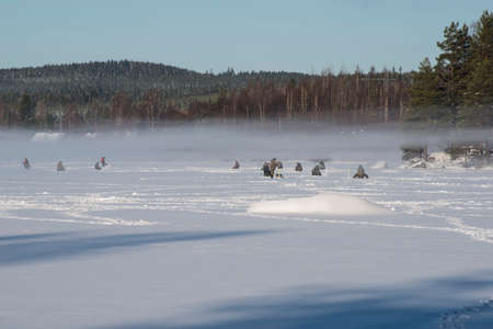 people icefishing on a lake in swedenの写真素材