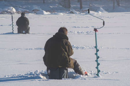 people icefishing on a lake in swedenの写真素材