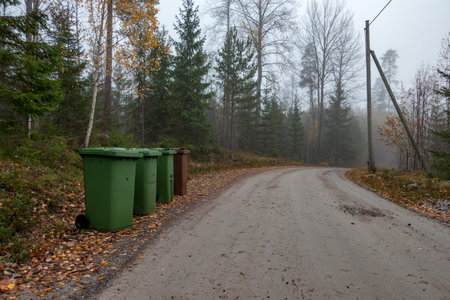 four trash cans beside a gravel road near Nykroppa sweden