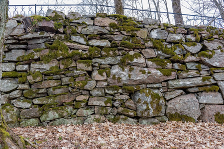an old manmade stone wall with moss on it