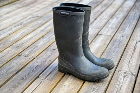 pair of green wellys standing on wooden deckingの写真素材
