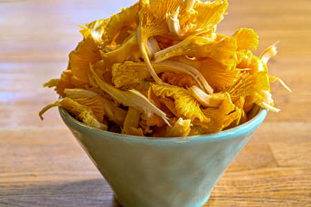 fresh yellow chanterelles in a bowl an a tableの写真素材