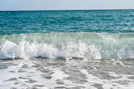 waves in mediterranean sea hitting the beachの写真素材